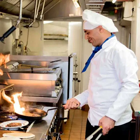 Camellia Gardens Chef Created Meals, chef frying a dish.