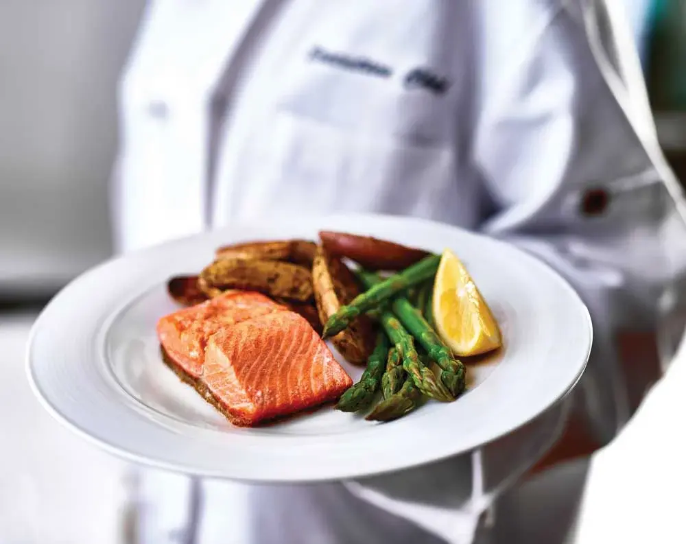 Camellia Gardens Chef Created Meals, chef delivering a finished dish.