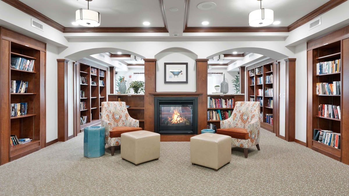 The library at Camellia Gardens with shelves of books and comfortable seating