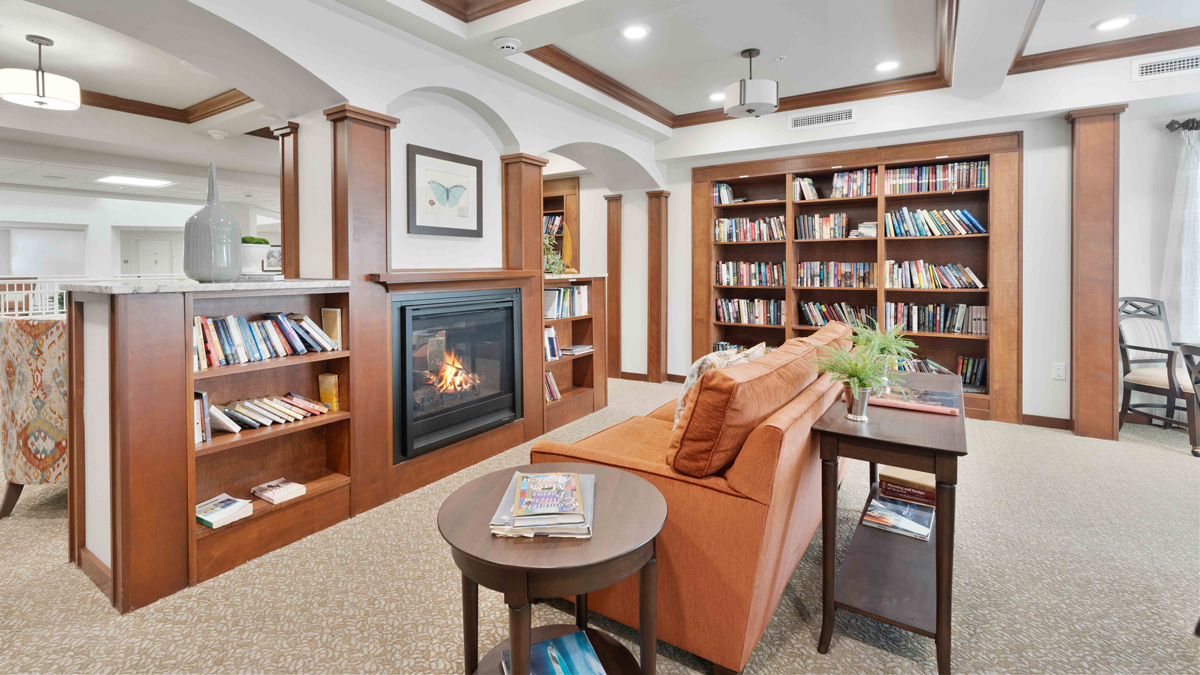 The library at Camellia Gardens with shelves of books and comfortable seating